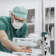 Medical professional operating equipment in a clinical setting.