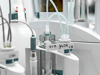 Laboratory equipment setup with various pipes that transfer media from different tubes to an analyzer.