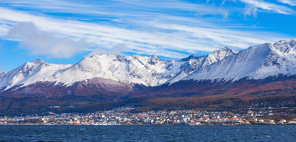 View of a town on the coast of South America with a snow-covered mountain range in the background
