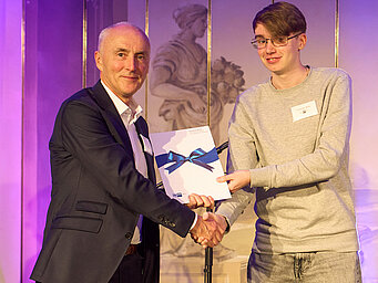 Johannes Weber of KNF Neuberger GmbH presents the Erich Becker Award to this year's winner, Alexander Müller.