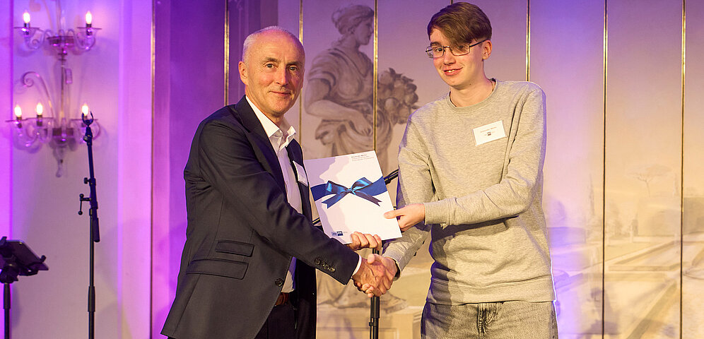 Johannes Weber of KNF Neuberger GmbH presents the Erich Becker Award to this year's winner, Alexander Müller.