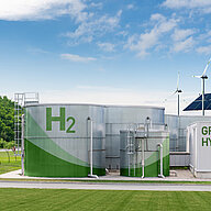 Green hydrogen facility with storage tanks and wind turbines.