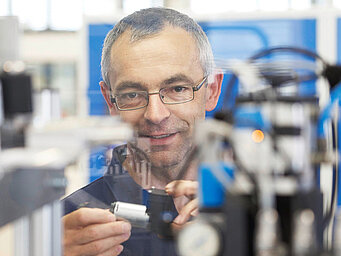 一位 KNF 工程师正在查看隔膜泵。KNF 生产多种隔膜泵和活塞式压缩机。 