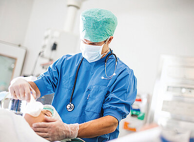 Ein Anästhesist kontrolliert den Narkostestatus der Patientin